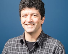 Headshot of Ricardo Schiavon with a blue background.