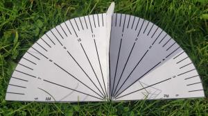 A paper sundial lying on the grass